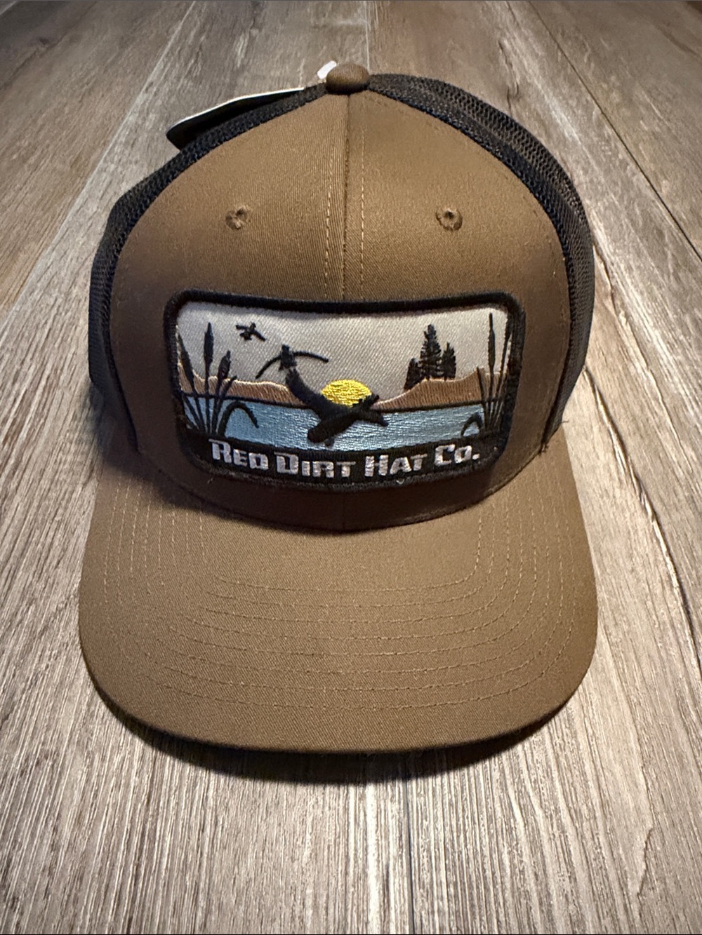 Red Dirt Hat Co. Duck Patch Hat is a caramel brown and black mesh trucker hat